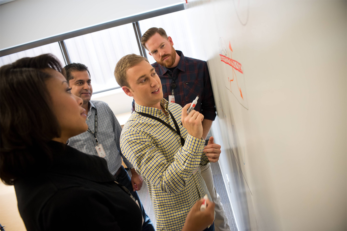 Associates collaborating at a whiteboard